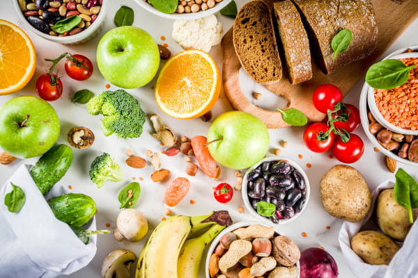 Fibras na dieta: diversos alimentos saudáveis sobre uma mesa.