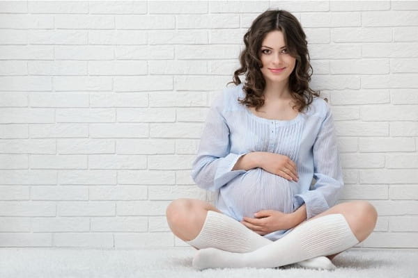 Nutrição na gravidez e lactação: mulher grávida na cozinha de sua casa.