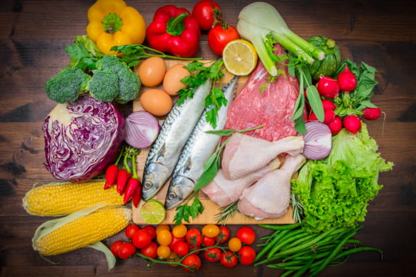 Sal na comida pode fazer mal: mesa com diversos vegetais, peixes, frangos e carne.